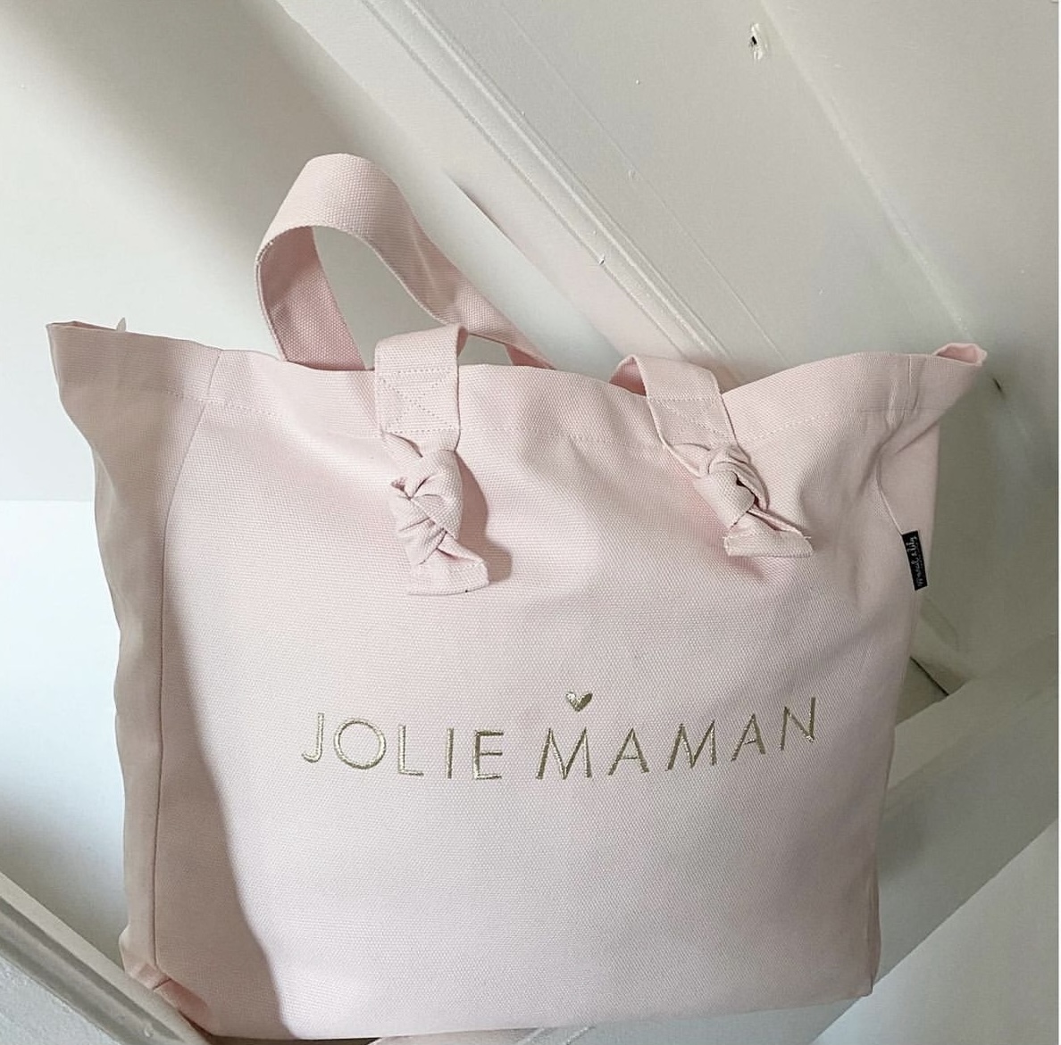 Idée Cadeau pour la fête des mamans ! Ce joli cabas rose en coton "Jolie Maman" avec ses petits nœuds et sa broderie pailleté or.